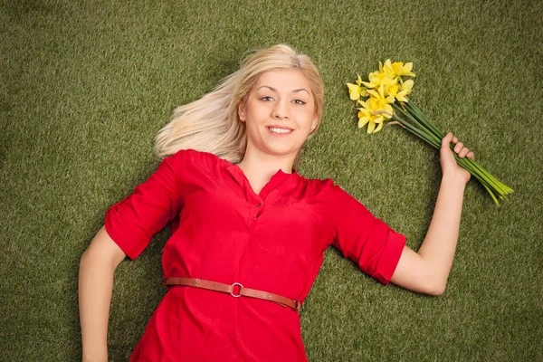 Vrouw op gras houden tulpen — Stockfoto