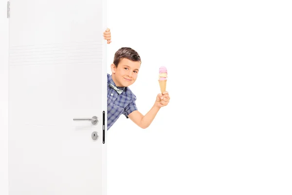 Ragazzino che tiene e gelato dietro una porta — Foto Stock