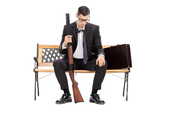 Depressed businessman holding a shotgun rifle — Stock Photo, Image