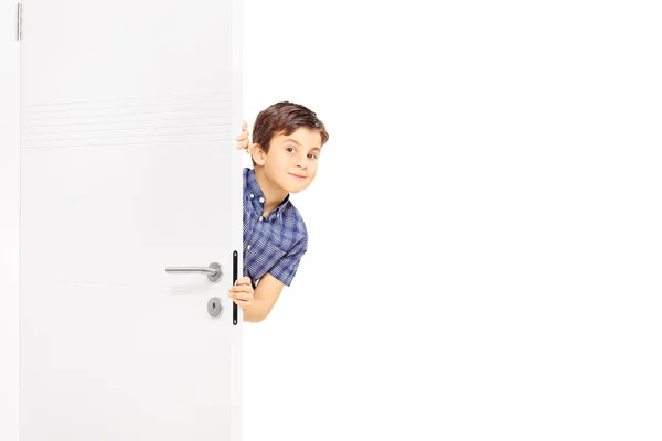 Pequeño niño mirar detrás de una puerta — Foto de Stock