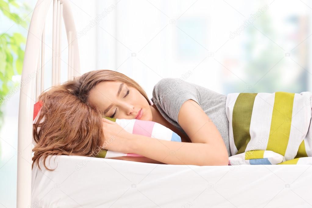 Beautiful young girl sleeping on bed