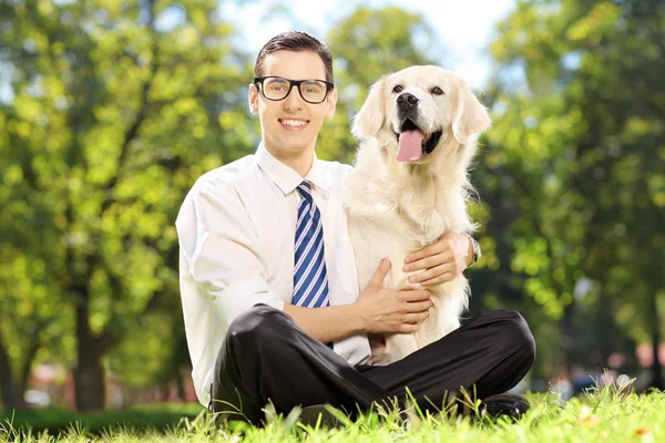 Man on grass hugging his dog i — Stock Photo, Image