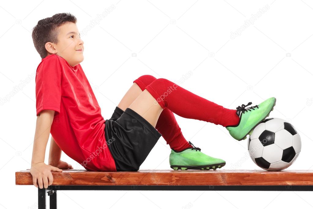 Boy in football uniform on bench
