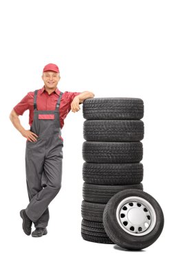 Erkek makinist lastikler üzerinde yaslanmış