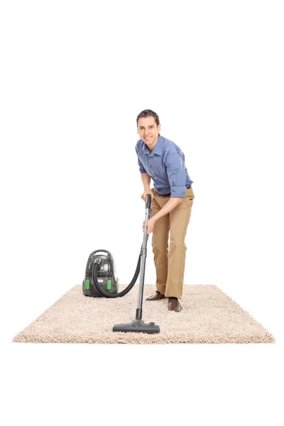 Homem limpeza com um aspirador de pó — Fotografia de Stock