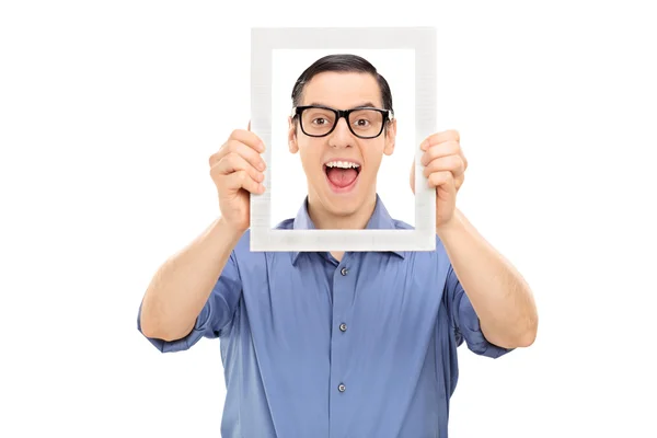 Guy posing behind picture frame — Stock Photo, Image