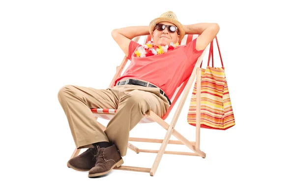 Senior gentleman sitting in a sun lounger — Stock Photo, Image