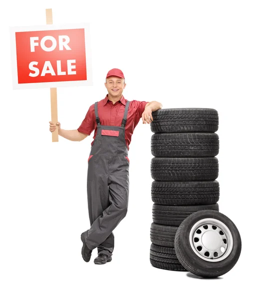 Mechanic standing by tires — Stock Photo, Image