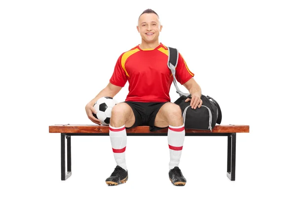 Ragazzo che tiene il calcio seduto su una panchina — Foto Stock