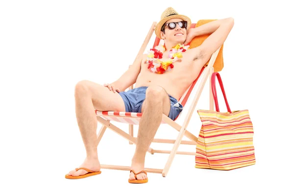 Shirtless man sitting in a sun lounger — Stock Photo, Image