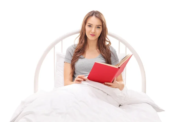 Frau liest Buch im Bett — Stockfoto