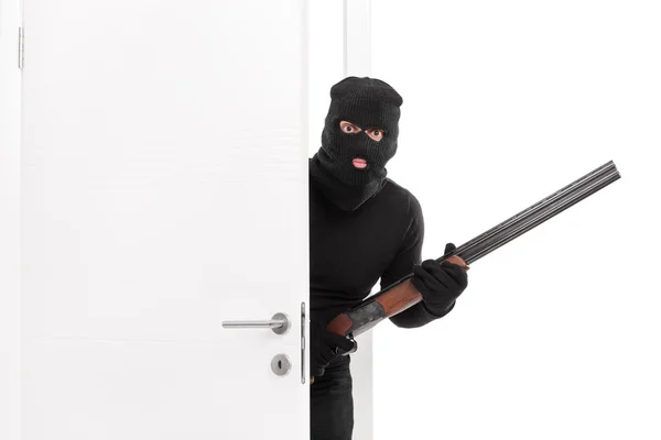 Masked terrorist entering room with a shotgun — Stock Photo, Image