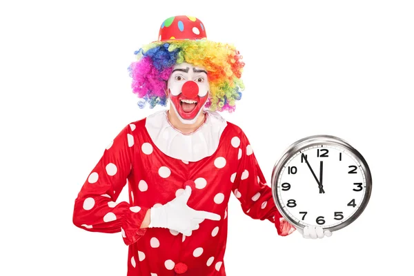 雄性小丑拿着墙上的钟 — 图库照片