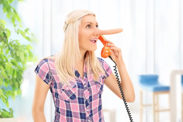 Dishonest woman speaking on the phone — Stock Photo, Image