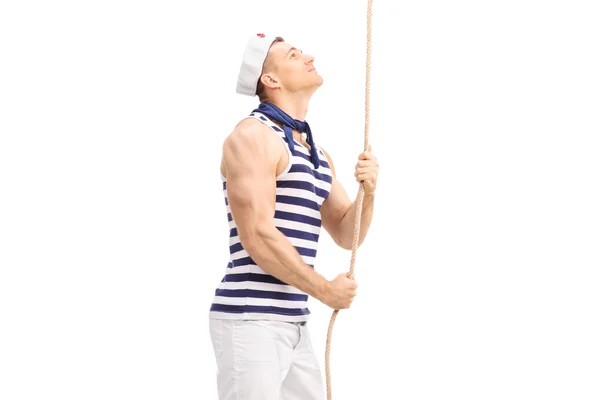 Handsome young sailor pulling a rope — Stock Photo, Image