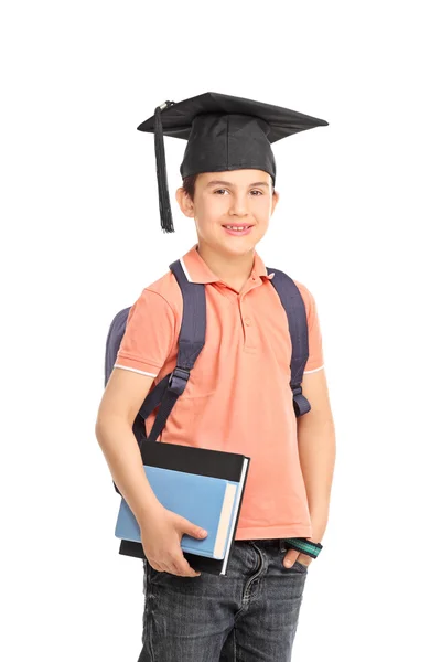 Colegial con sombrero de graduación sosteniendo libros —  Fotos de Stock