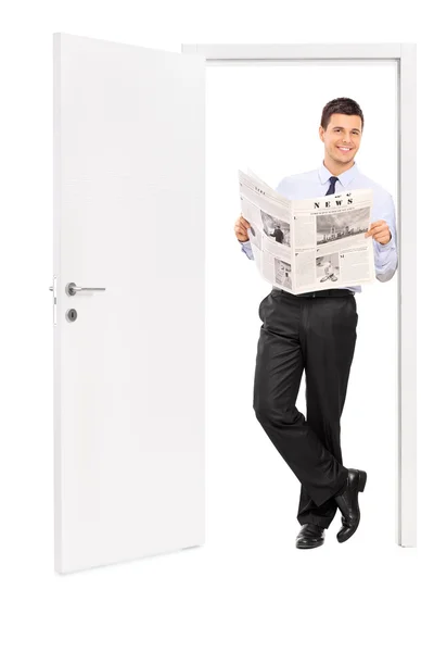 Hombre leyendo el periódico e inclinando una puerta —  Fotos de Stock