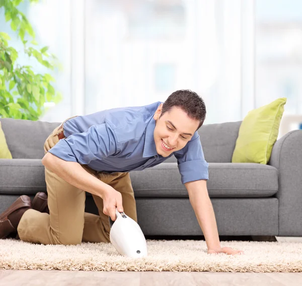 Man with a handheld vacuum cleaner — Stock Photo, Image