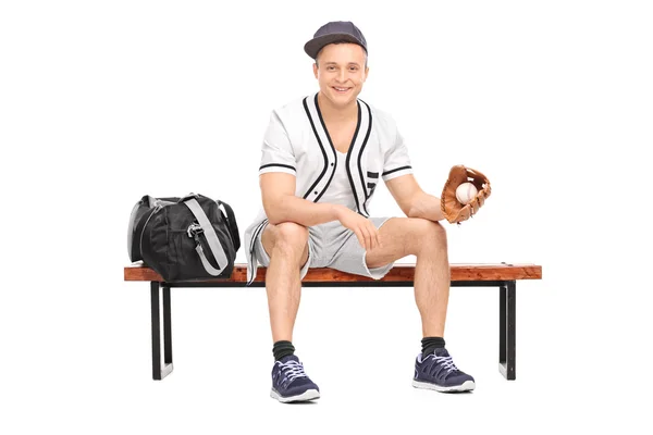 ベンチで野球のボールを保持しているスポーツマン — ストック写真