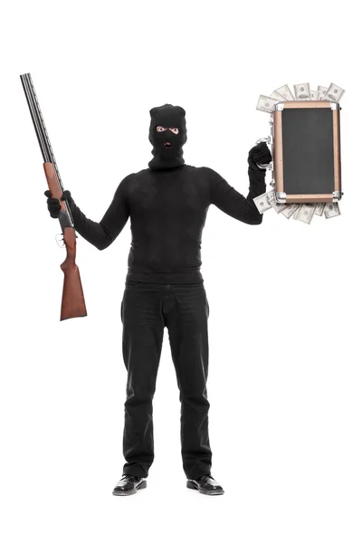 Thief holding bag with money and a shotgun — Stock Photo, Image