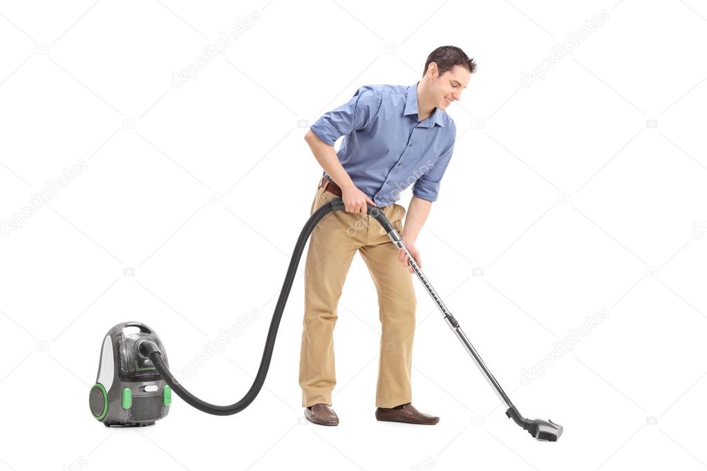 Young man using a vacuum cleaner