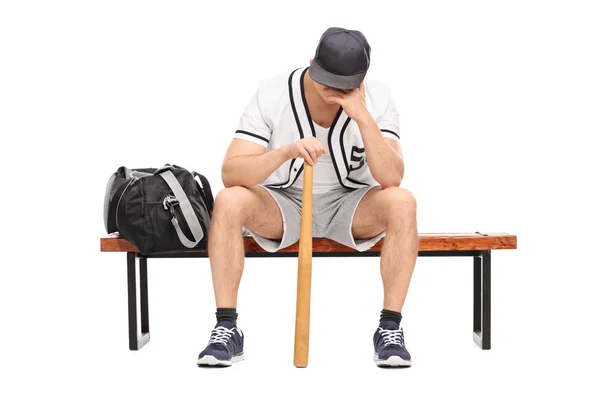 Sorgliga baseballspelare satt på en bänk — Stockfoto