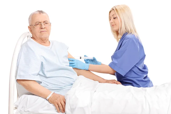Doktor dává injekce do starší pacient — Stock fotografie