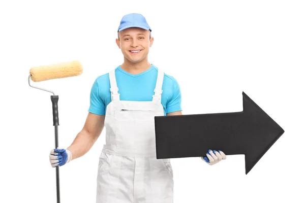 Young male decorator holding arrow — Stock Photo, Image