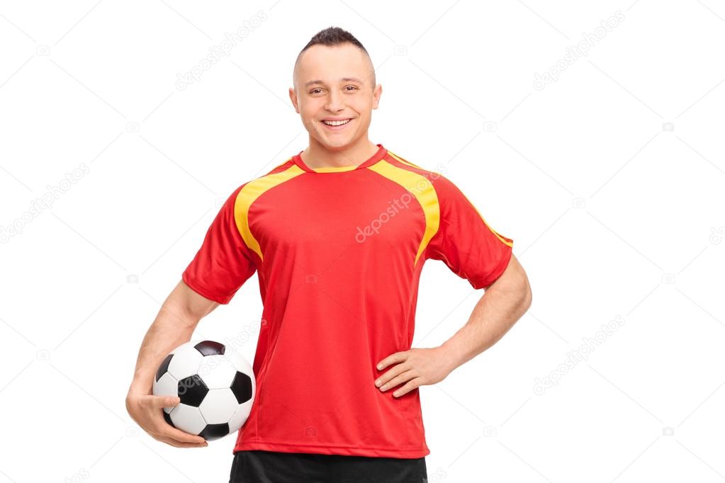 Young soccer player holding a ball