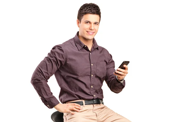 Man on chair and holding mobile phone — Stock Photo, Image