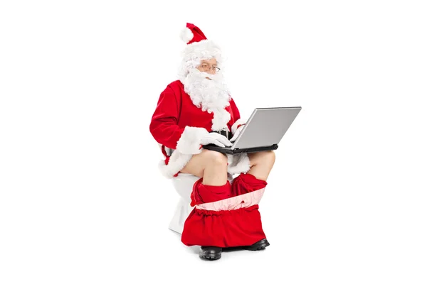 Papai Noel no banheiro trabalhando com laptop — Fotografia de Stock