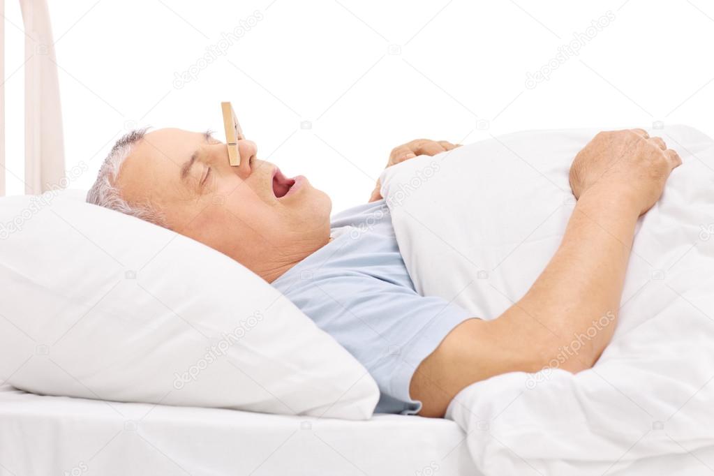 Senior sleeping with a clothespin on nose