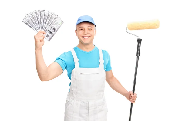 Decorator holding een verfroller en geld — Stockfoto