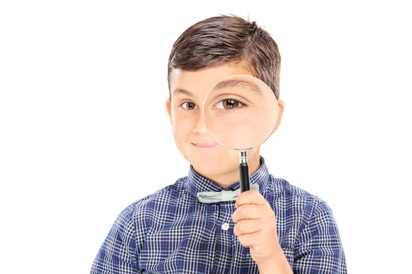 Boy looking through a magnifying glass — Stock Photo, Image