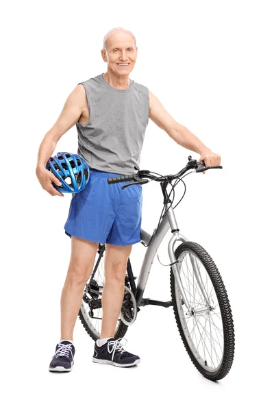 Пожилой мужчина позирует рядом с велосипедом — стоковое фото