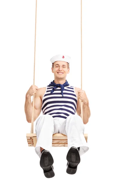 Cheerful young sailor swinging on a swing — Stock Photo, Image