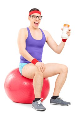 Nerdy guy sitting on fitness ball clipart