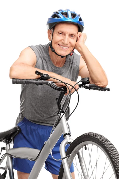 Senior in sportkleding leunend op een fiets — Stockfoto