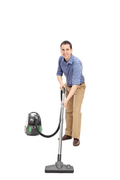 Adam bir elektrikli süpürge ile temizlik — Stok fotoğraf