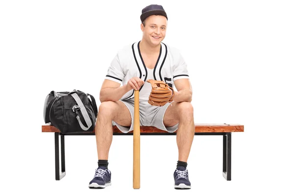 Jovem jogador de beisebol sentado no banco — Fotografia de Stock