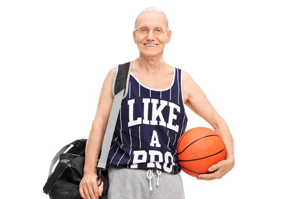 Senior man in sportkleding bedrijf een basketbal — Stockfoto