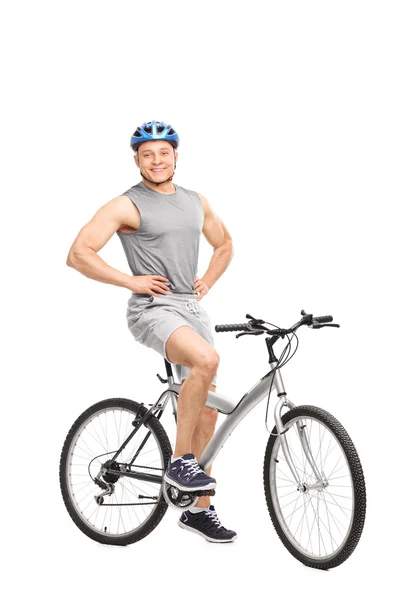 Junger Mann posiert auf einem Fahrrad sitzend — Stockfoto