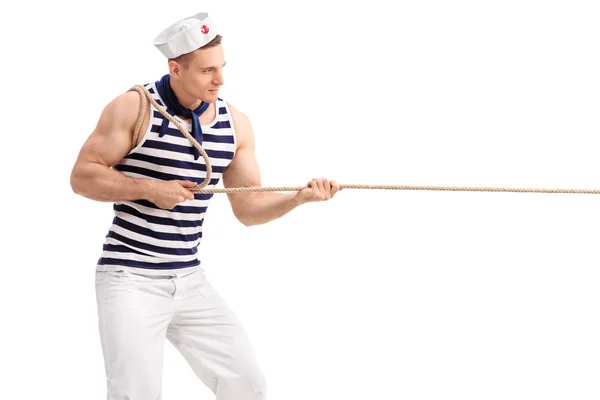 Homem de uniforme de marinheiro puxando uma corda — Fotografia de Stock