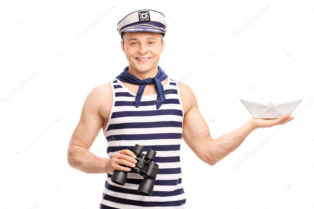 Sailor holding binoculars and a paper boat 