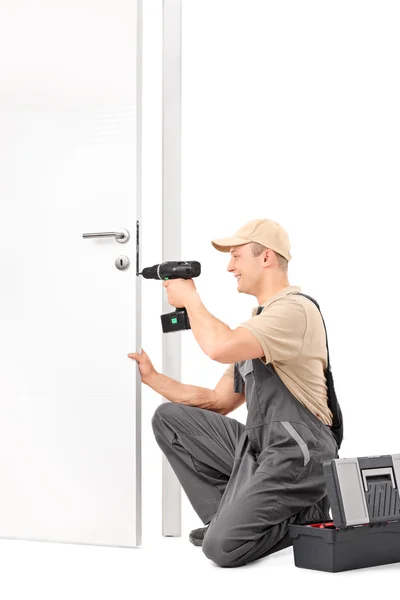 Male locksmith installing a door lock — Stock Photo, Image