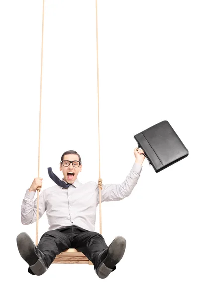 Excited businessman swinging on a swing — Stock Photo, Image