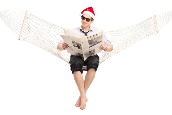 Guy in hangmat lezen van een krant — Stockfoto