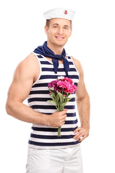 Handsome sailor holding a bouquet of flowers — Stock Photo, Image
