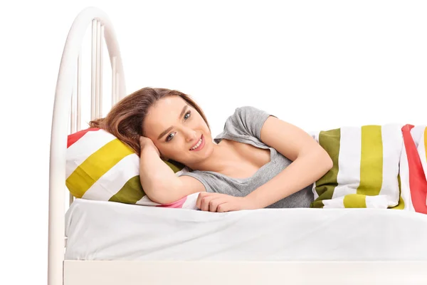 Jonge brunette vrouw liggen in een bed — Stockfoto