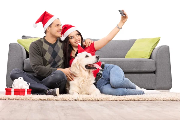 Casal com chapéus de Papai Noel tirar uma selfie — Fotografia de Stock